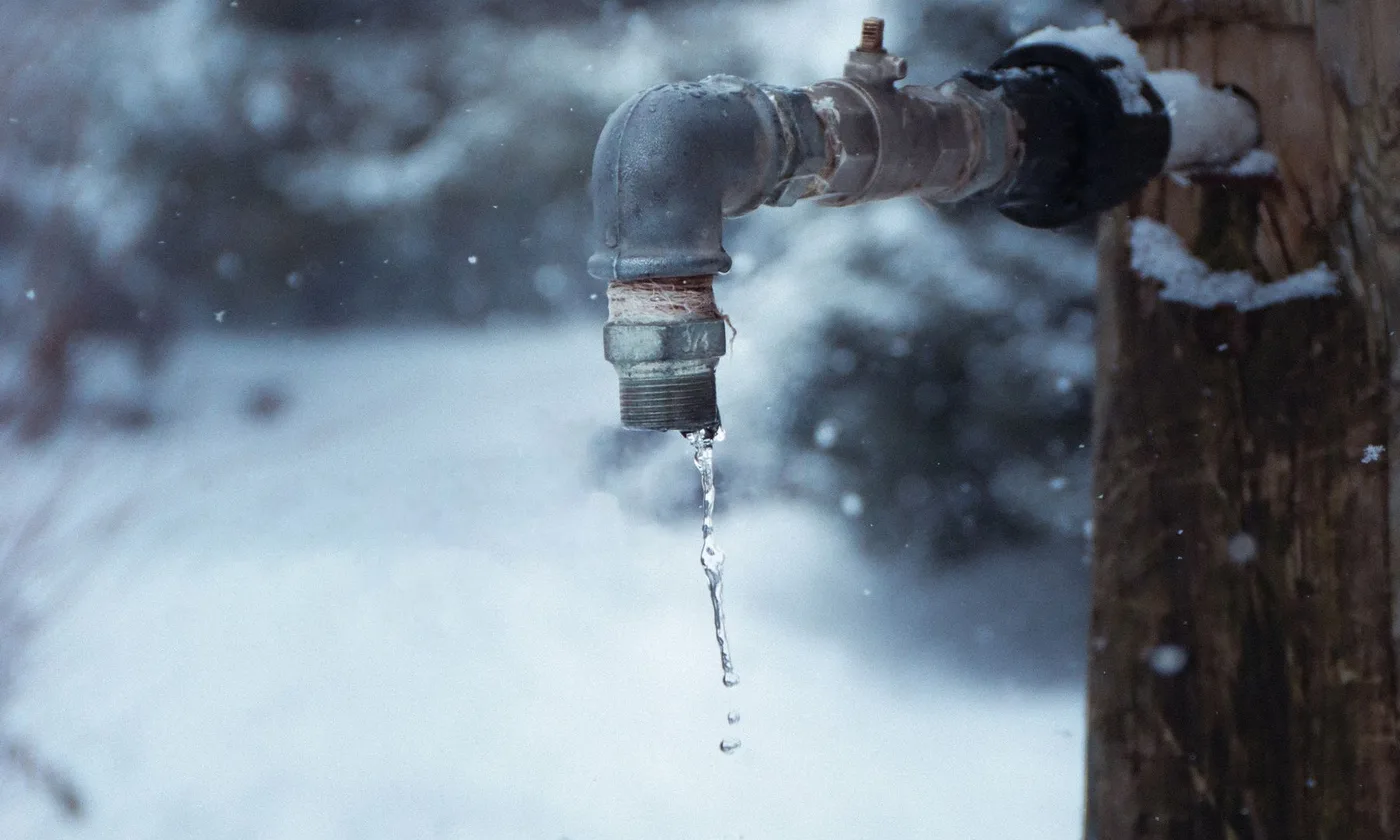 Frozen outdoor tap dripping in winter